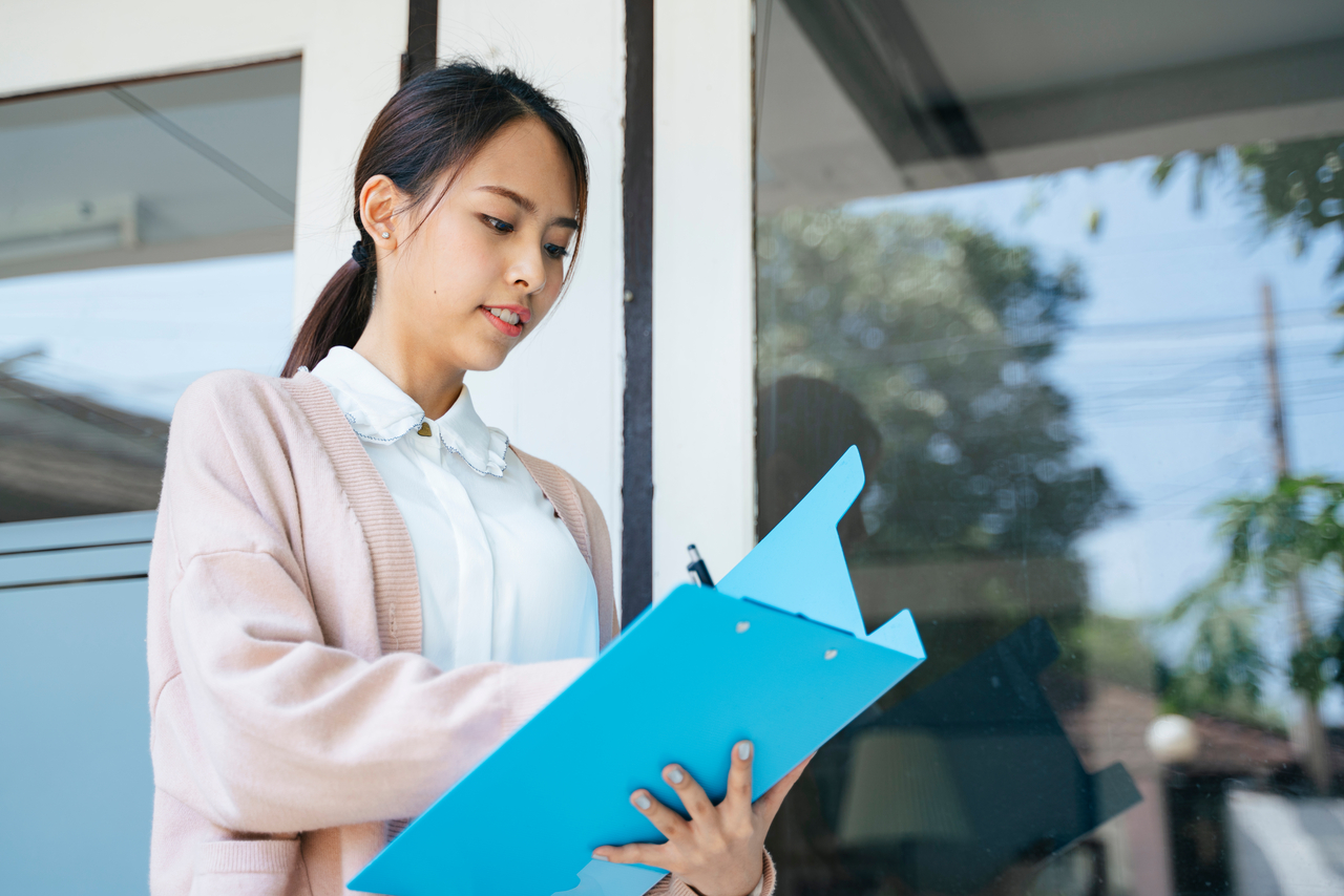 女性がクリップボードで書く